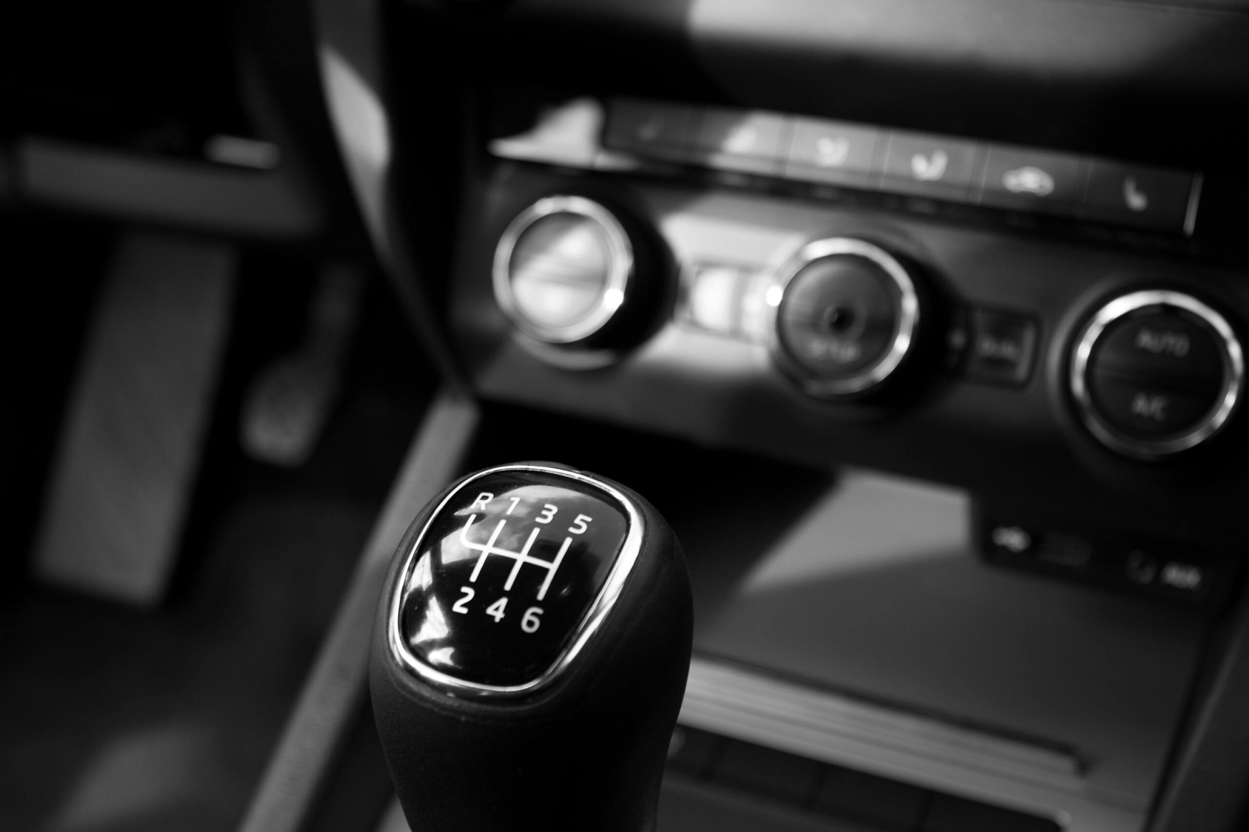 Close-up of a car gear shift in a black and white artistic design.